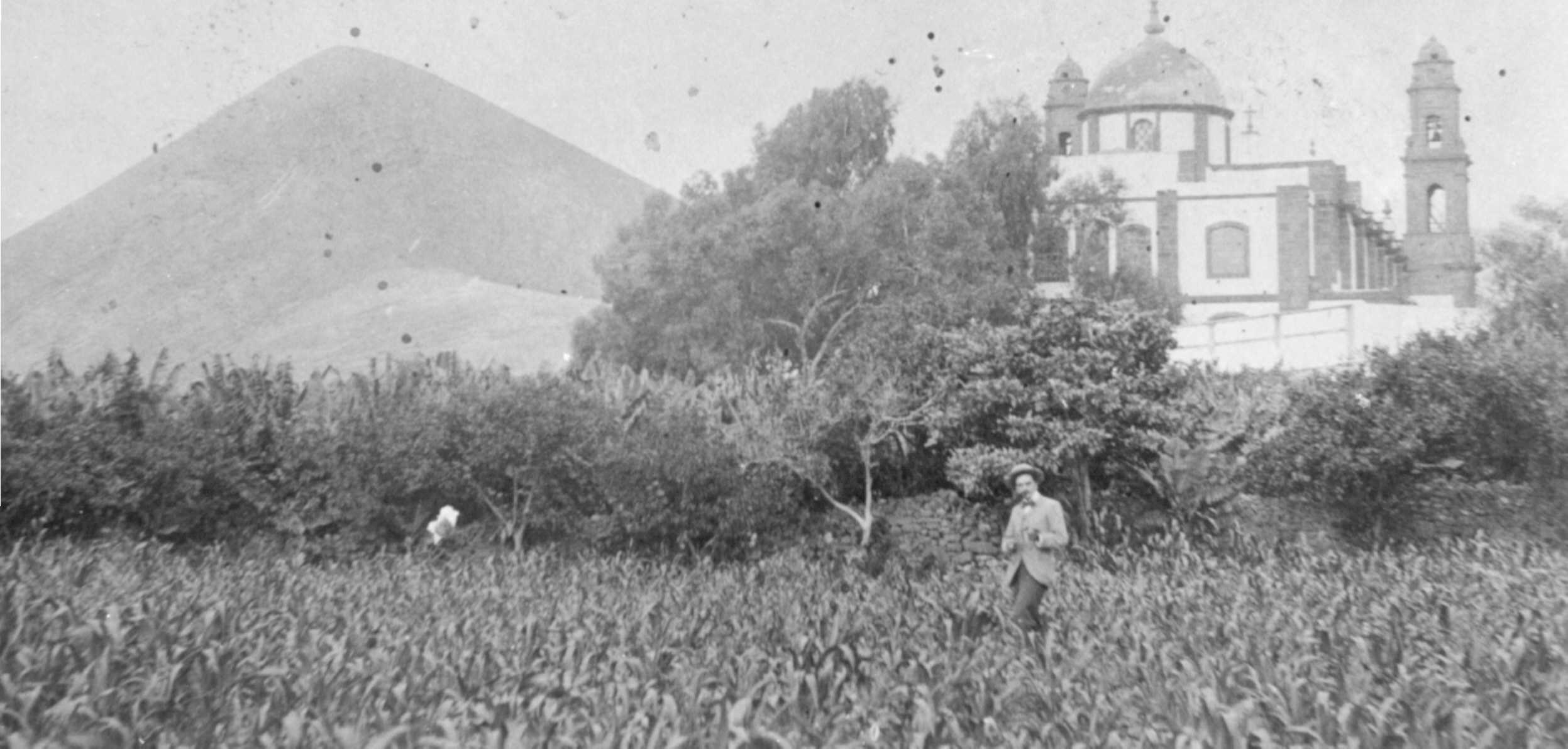 Trasera de la Iglesia vista desde una cercana huerta de frutales y millo.